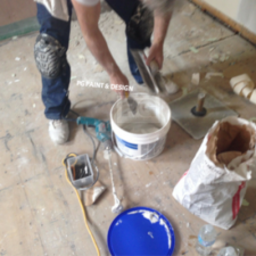 painter preparing drywall compound mix to repair ceiling before painting