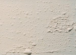 painted interior wall showing paint blistering and bubbling paint