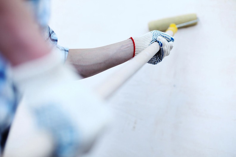 professional painter painting a wall with a paint roller